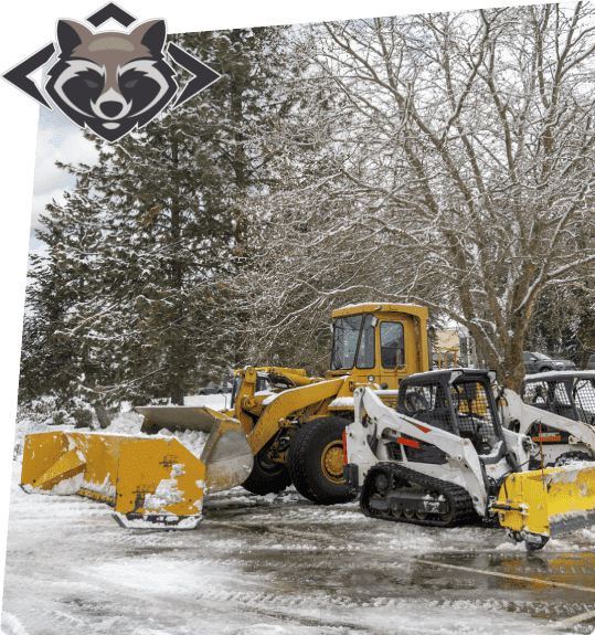 A snow plow and a tractor in the middle of a parking lot.